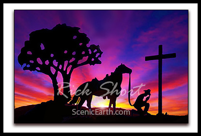 A digital painting of a silhouetted cowboy kneeling at the cross against an amazing bright and colorful sunset